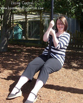 A person sitting on a swing in a park