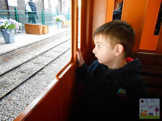 A young boy sitting at a train station