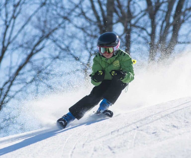 A man riding a snowboard down a snow covered slope