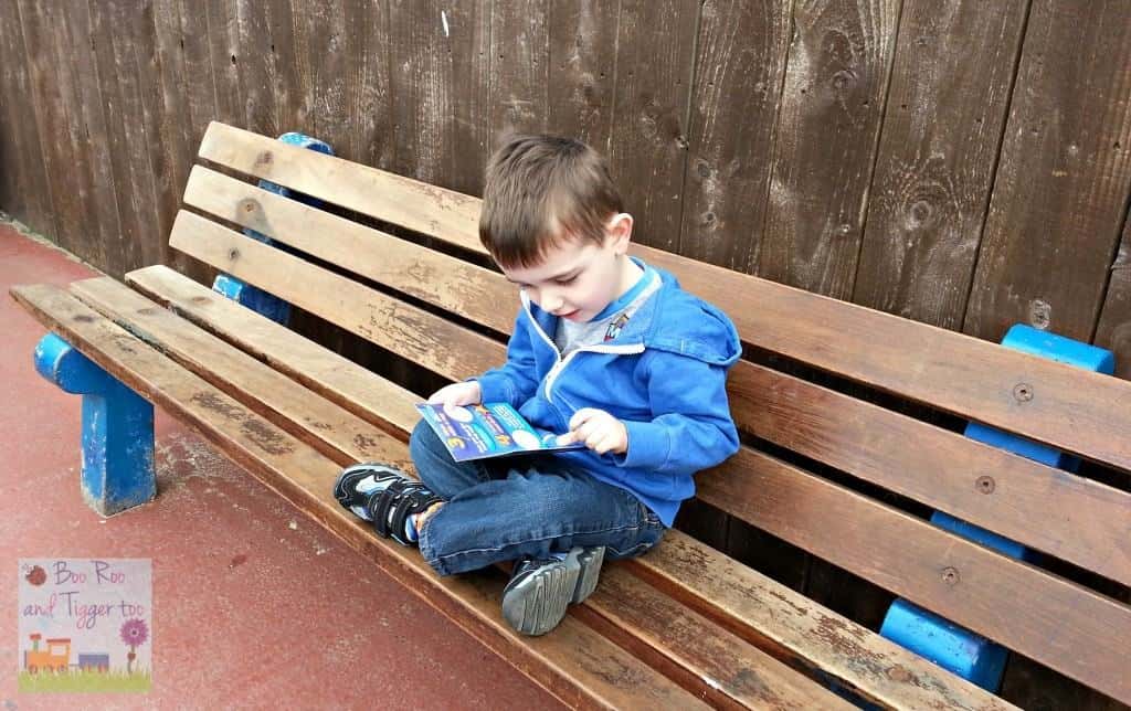 A boy sitting on a wooden bench