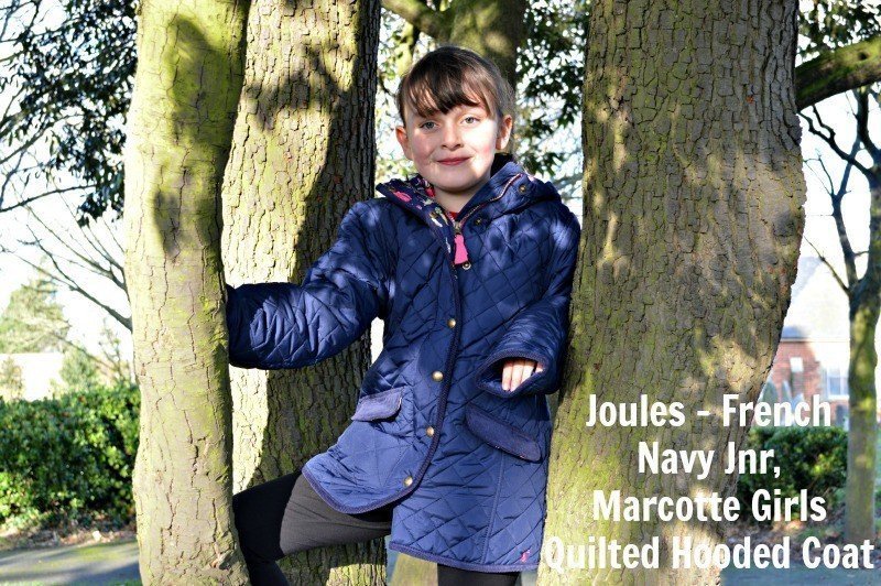 A young boy standing next to a tree