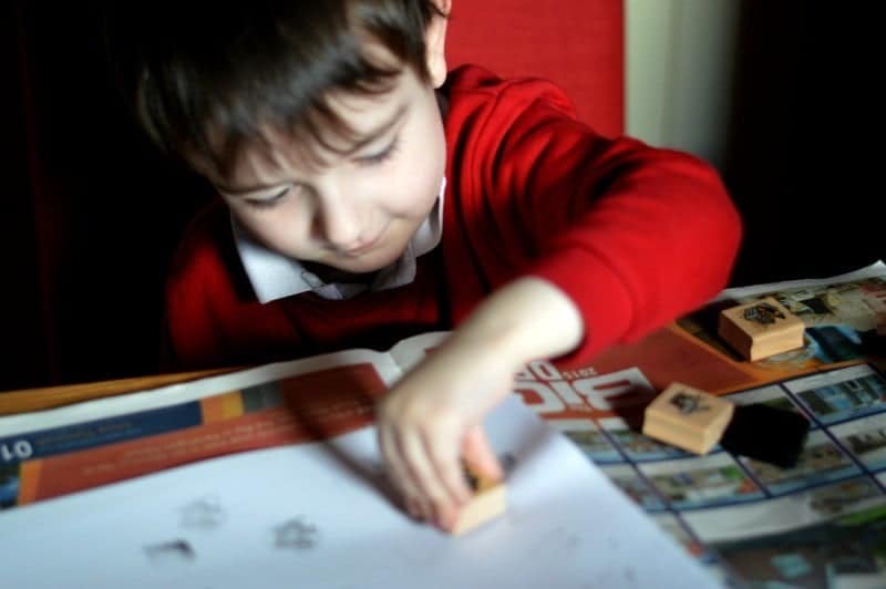 A young boy sitting at a table using a laptop