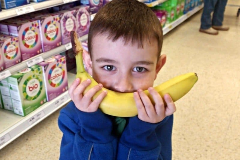 A young boy holding a banana