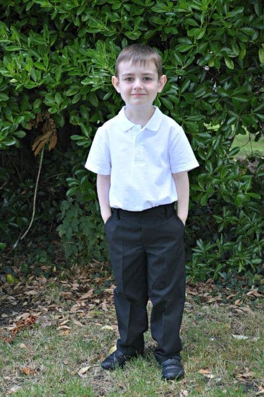 A little boy that is standing in the grass