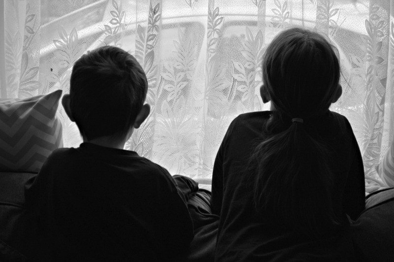 A man and a woman sitting in front of a window