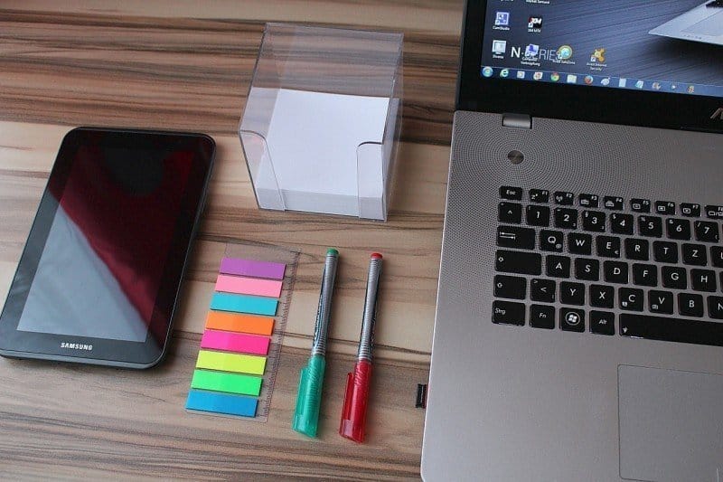 A laptop computer sitting on top of a wooden table