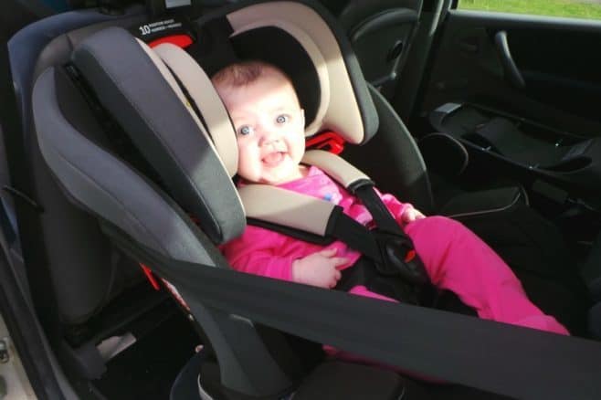 A small child sitting on the seat of a car