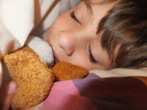 A little girl holding a teddy bear