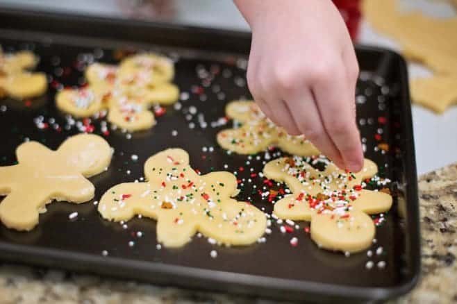 A close up of a cutting board with a cake, with Cookie