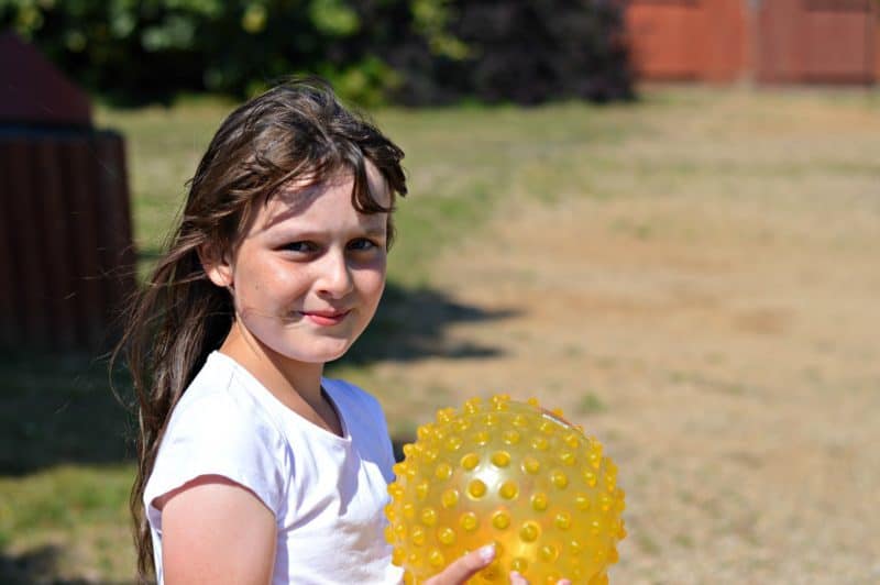 A young girl holding a football ball