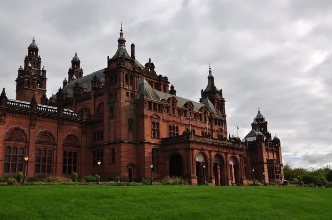 A large clock tower in front of Kelvingrove Art Gallery and Museum