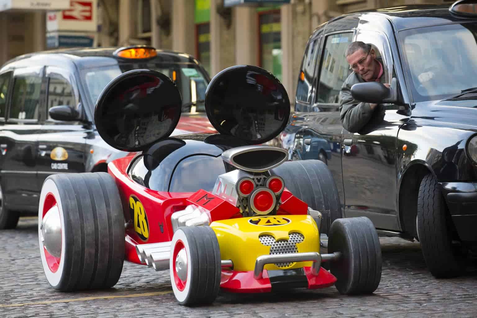 A truck driving down a street next to a car