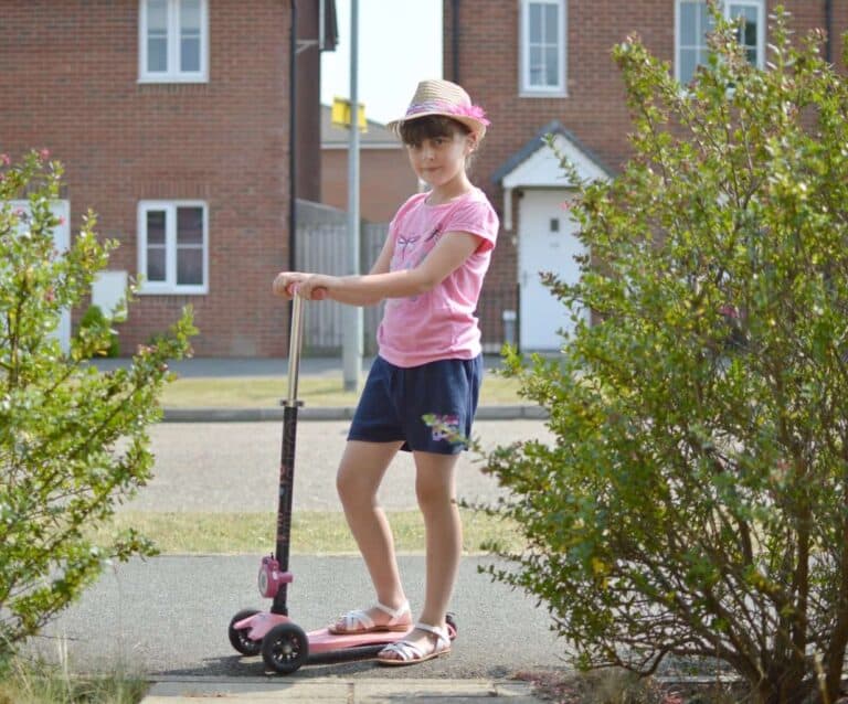 A young girl riding a skateboard up the side of a building