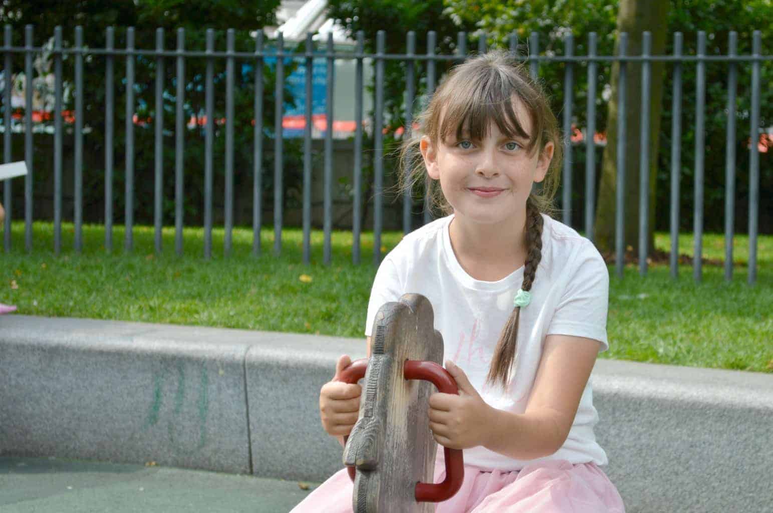 A little girl sitting in a parking lot