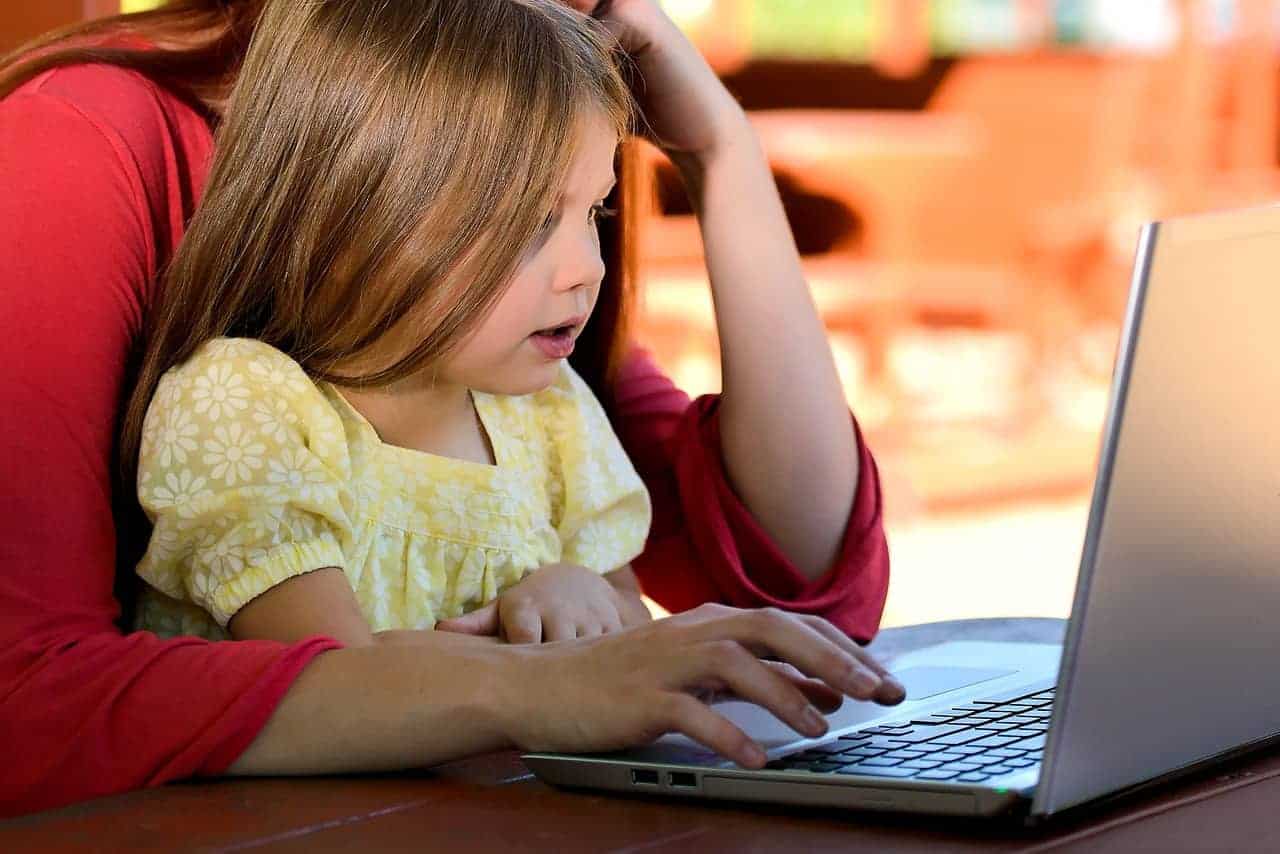 A person sitting at a table using a laptop computer