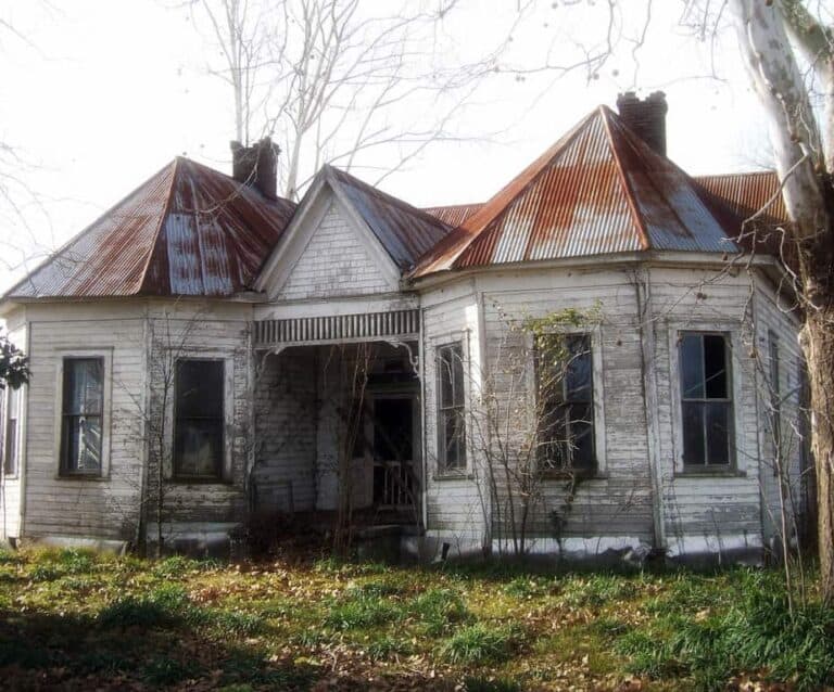 An old brick house with trees in the background