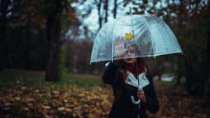 A woman walking in the rain holding an umbrella