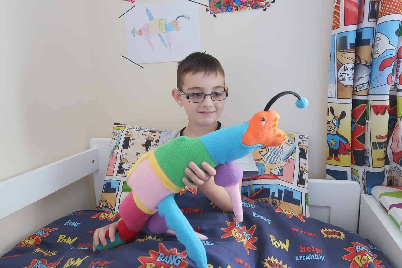 A little boy sitting in a bedroom