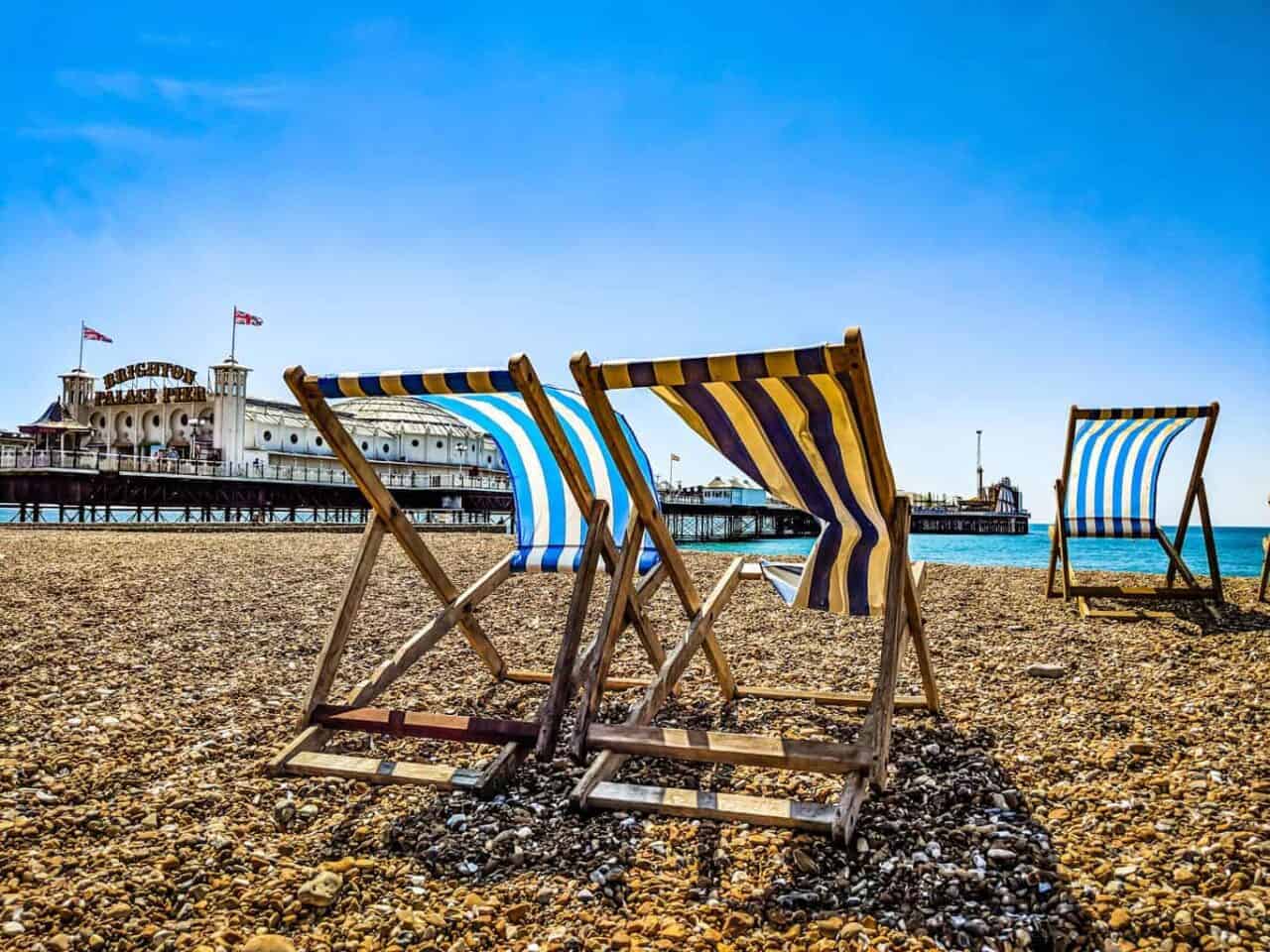 A row of wooden benches sitting on top of a beach