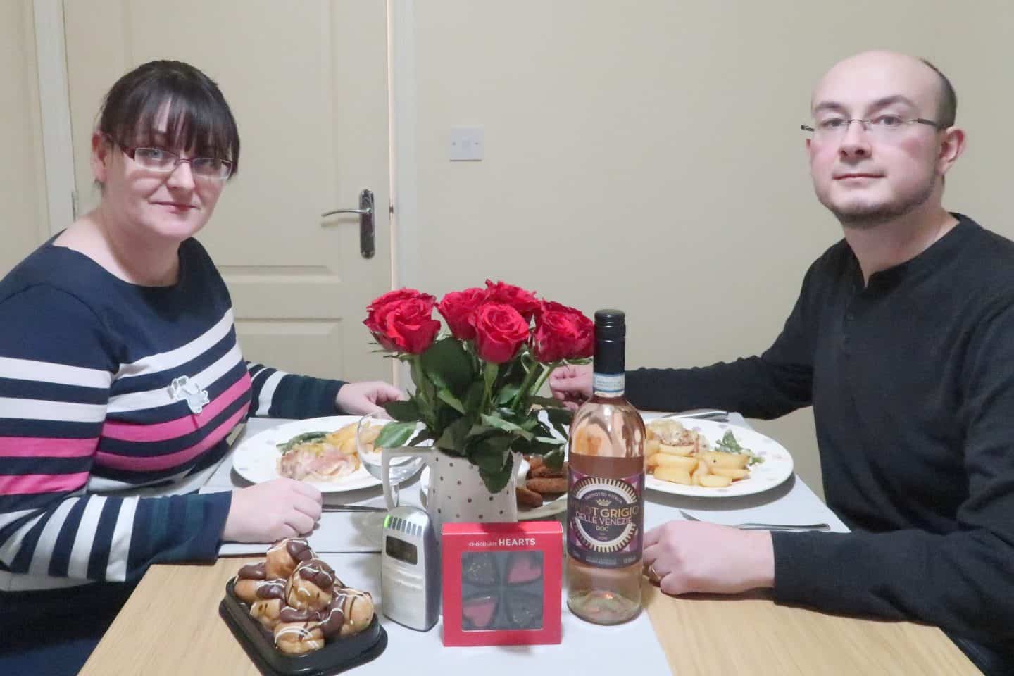 A man and a woman sitting at a table with food, with Design and Dinner