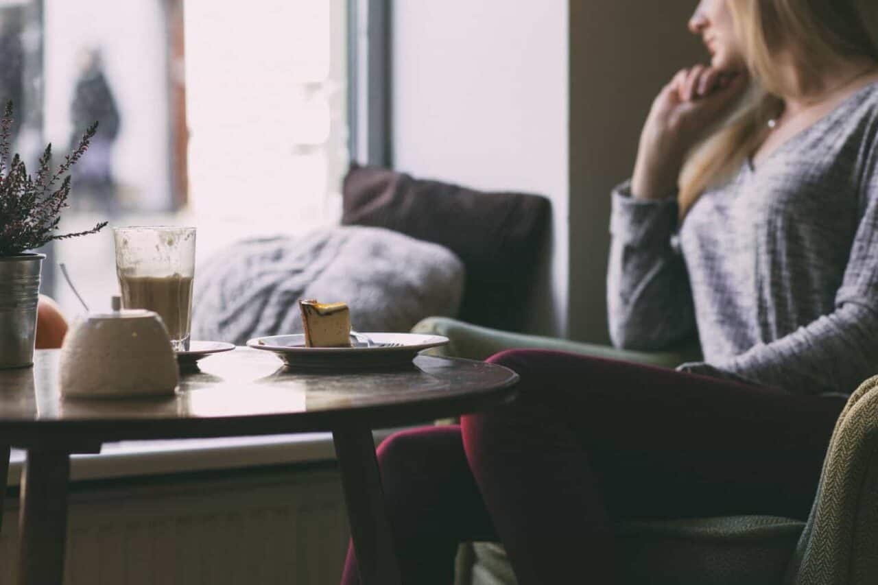 A person sitting at a table in front of a window