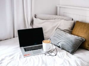 A bedroom with a bed and a laptop