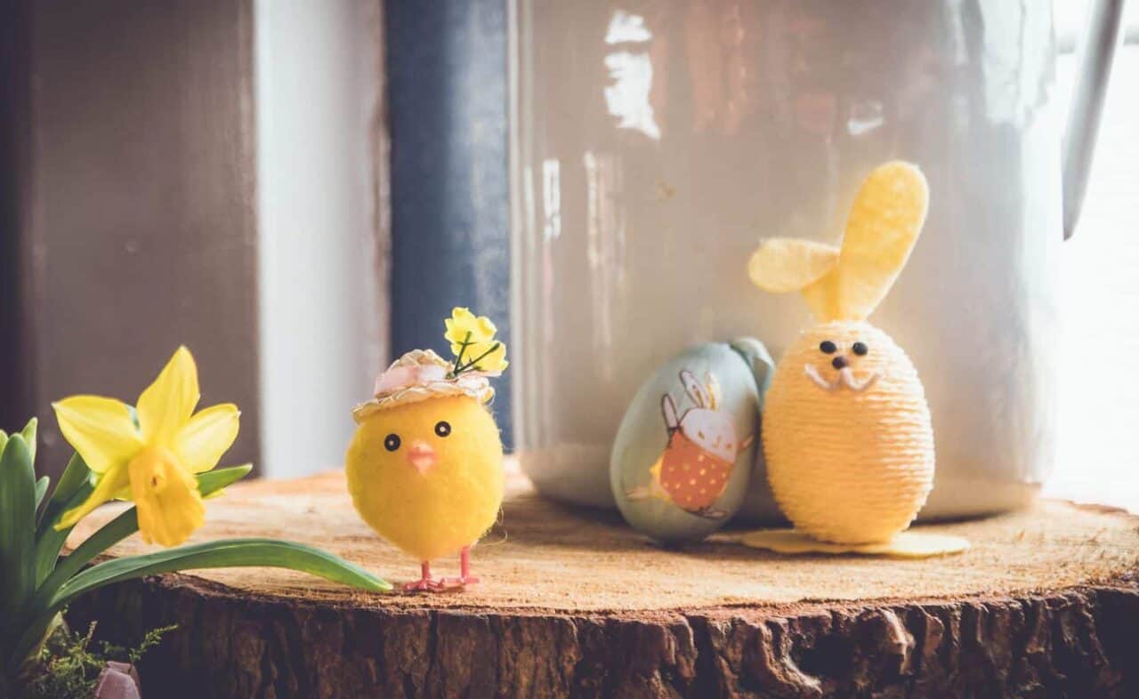 A group of stuffed animals sitting next to a vase