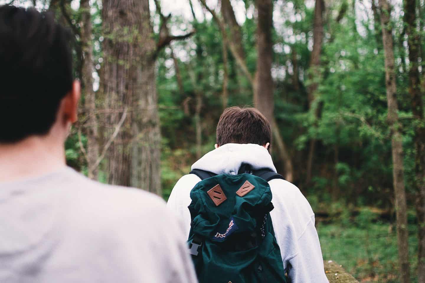 A man standing next to a forest