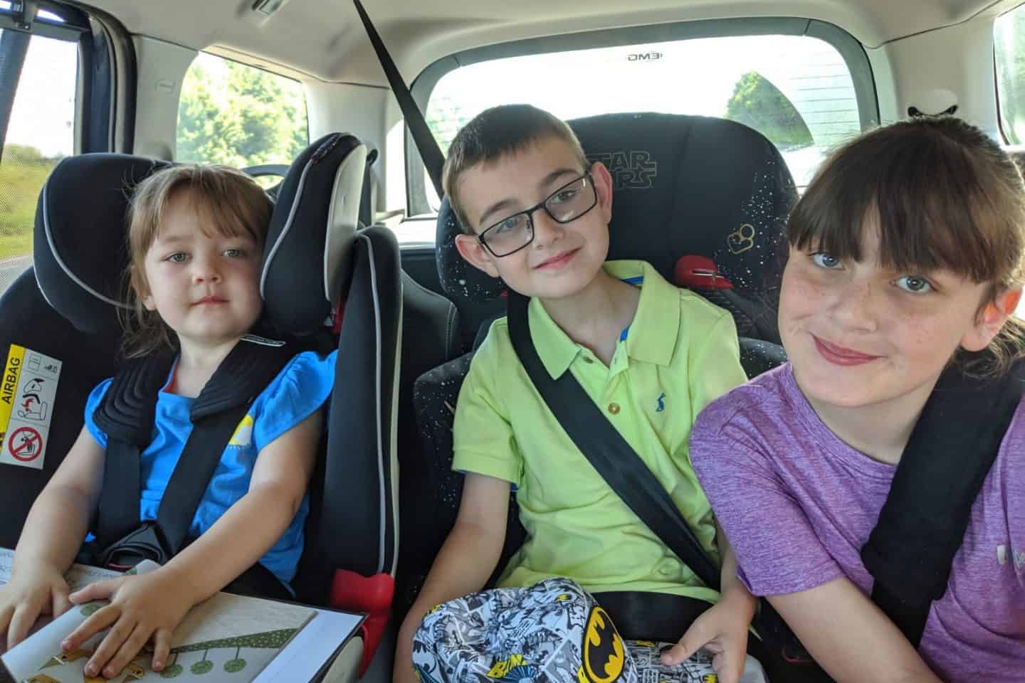 A group of people sitting around a car