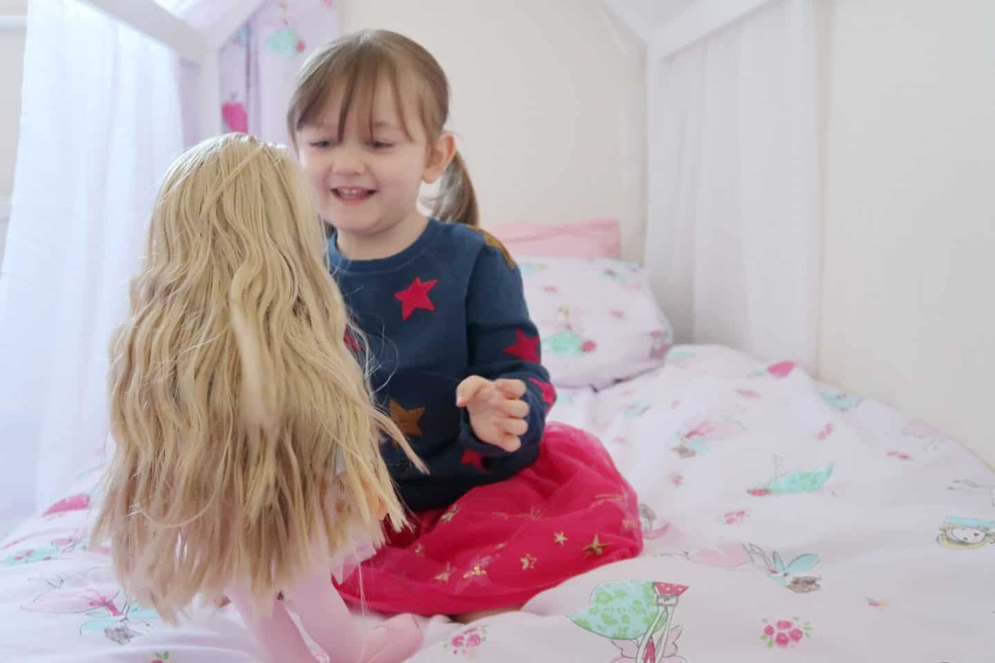 A little girl sitting on a bed