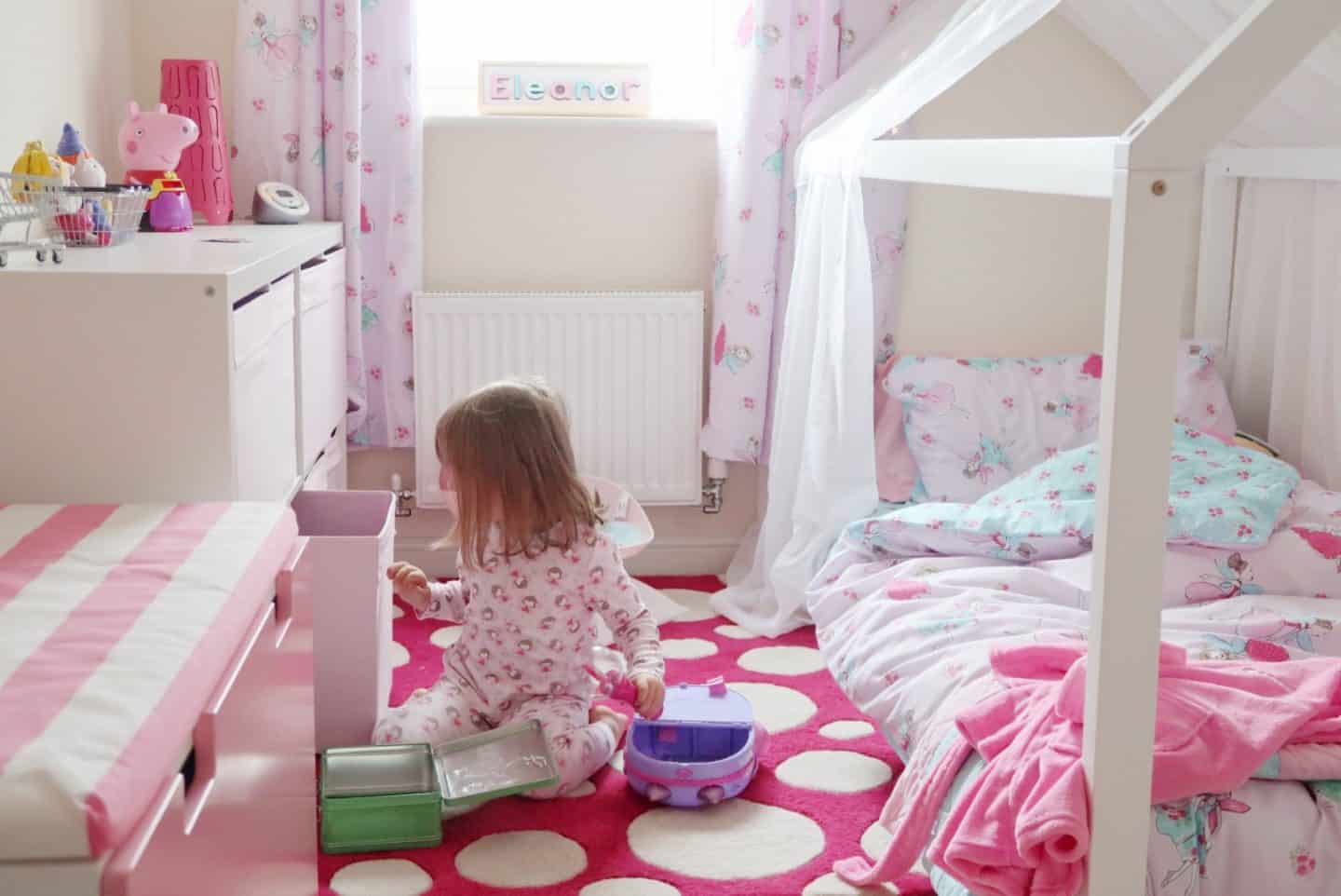 A little girl sitting on a bed