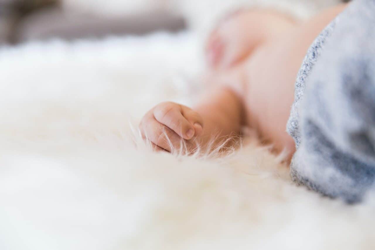 baby laying on a white fluffy blanket