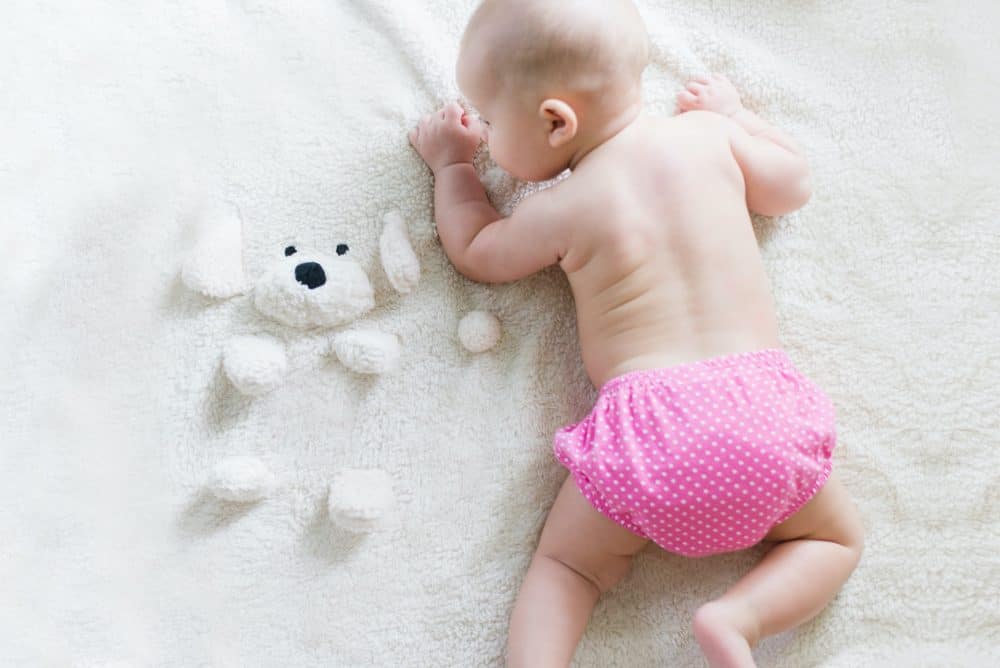 eco-friendly switches any new parent can make - baby crawling with a pink cloth nappy