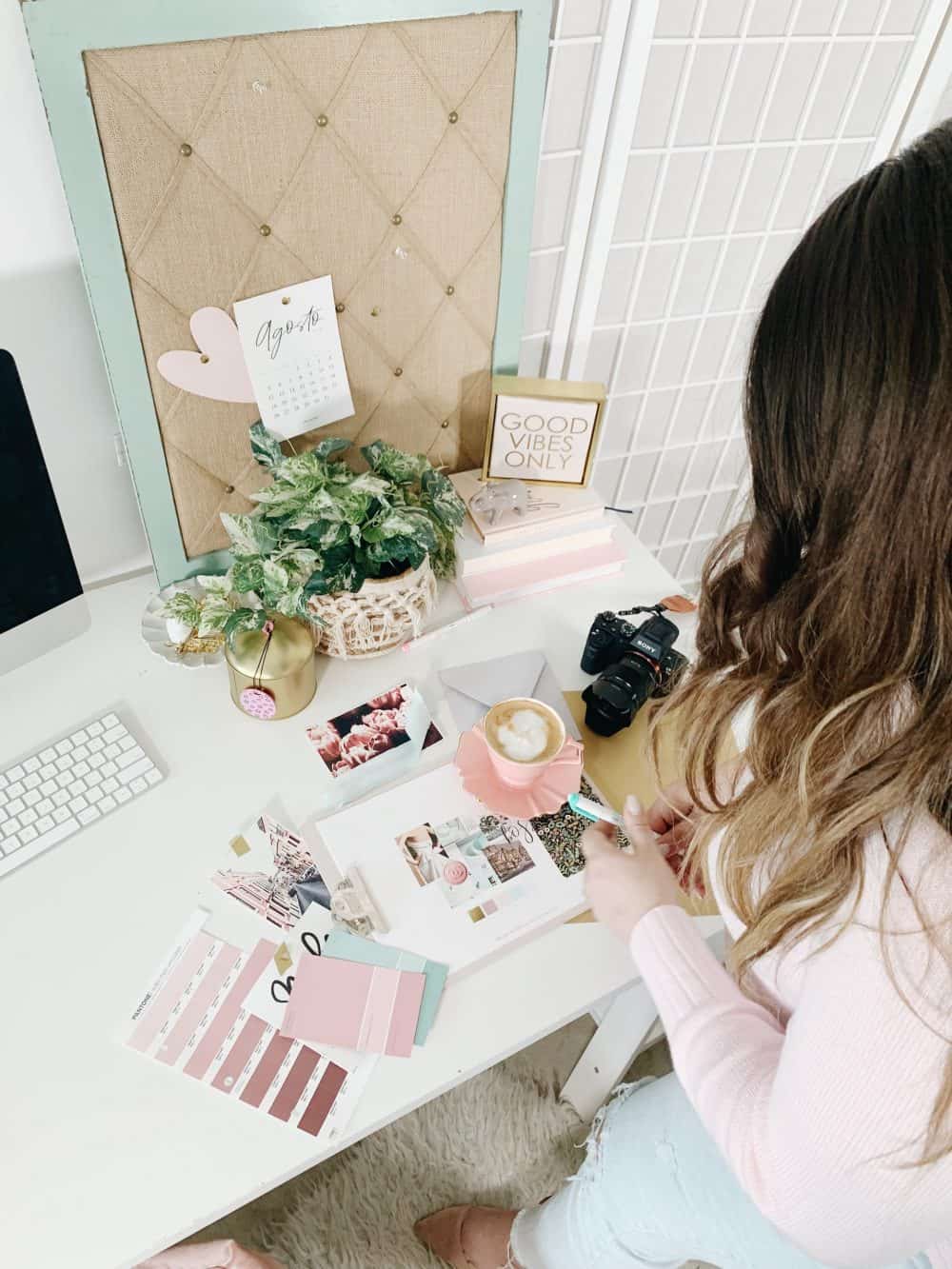 How to create graphics for your blog - Branding process on a pink desk with candles, coffee, Pantone colors and plants