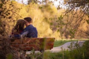 photography of couple sitting on bench