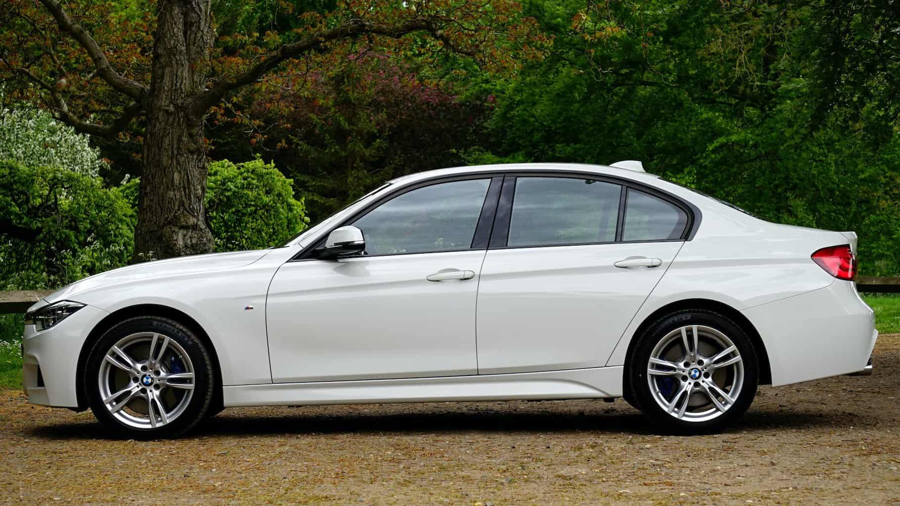 What To Do if Your Car is too Expensive to Insure - white bmw sedan parked beside tree