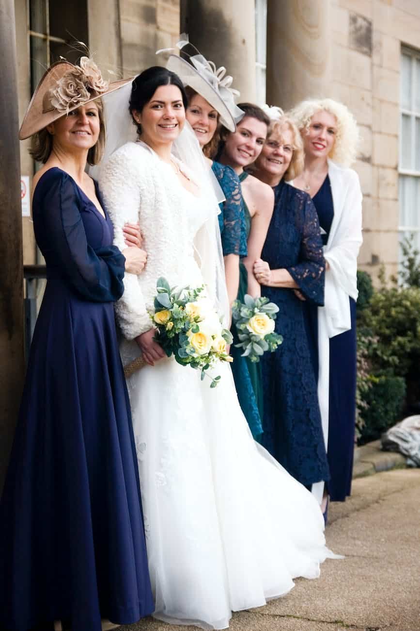 a bride holding a bouquet of flowers with friends and family