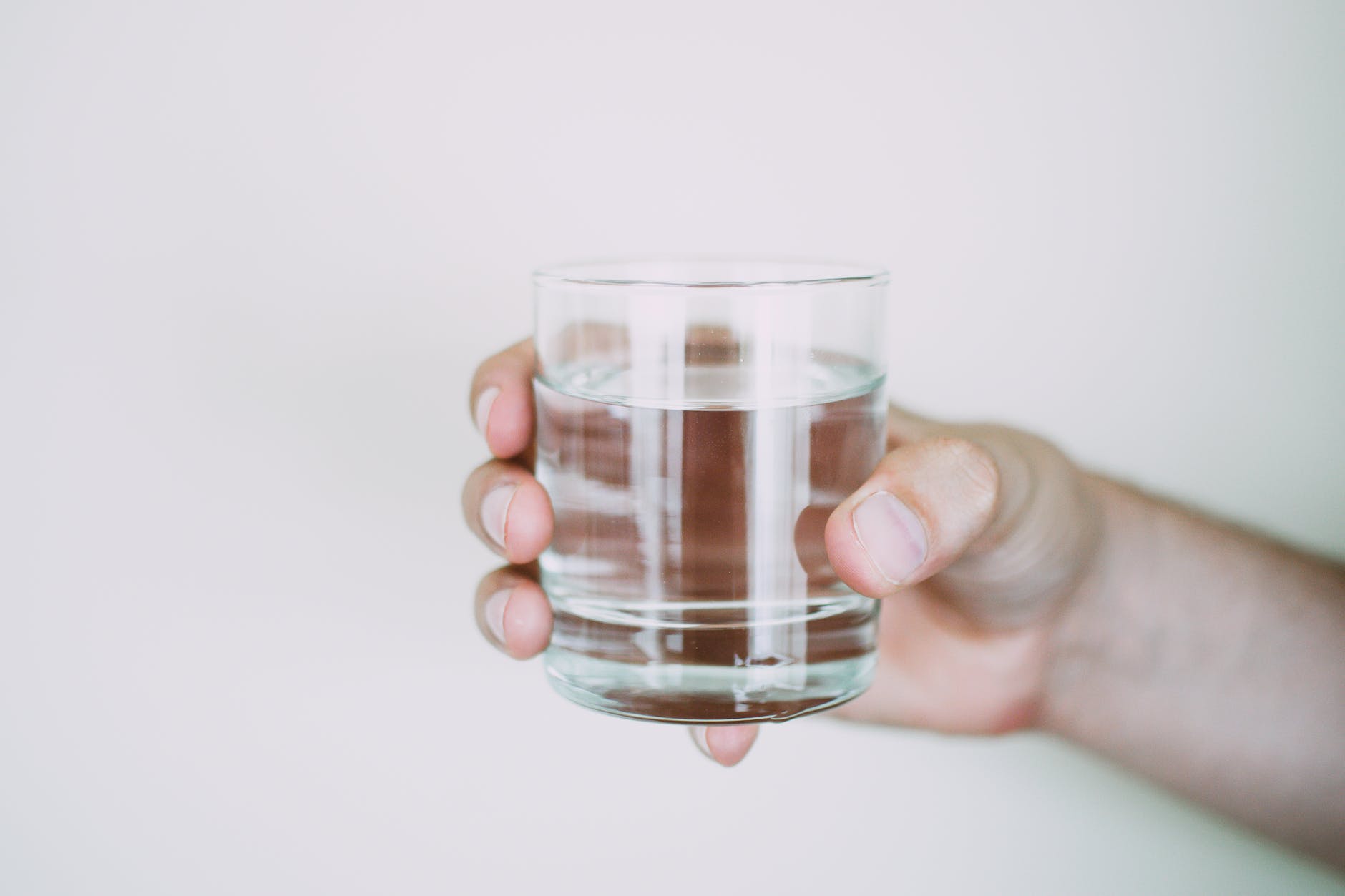 person holding drinking glass - 10 Benefits of Installing a Home Water Filter System