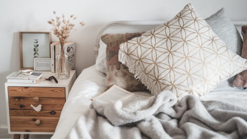 white and brown throw pillow on white bed - Factors to Consider When Buying a Bed