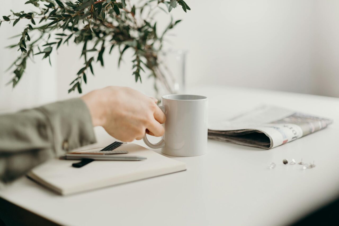 person holding white ceramic mug