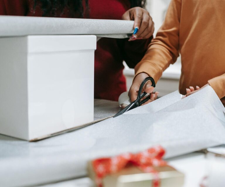 photo of a person s hands cutting wrapping paper