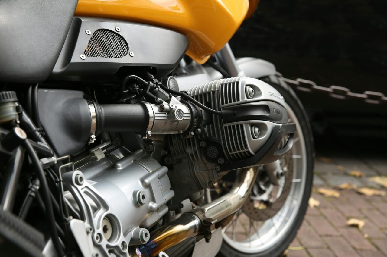 yellow and gray motorcycle parks near chain rail