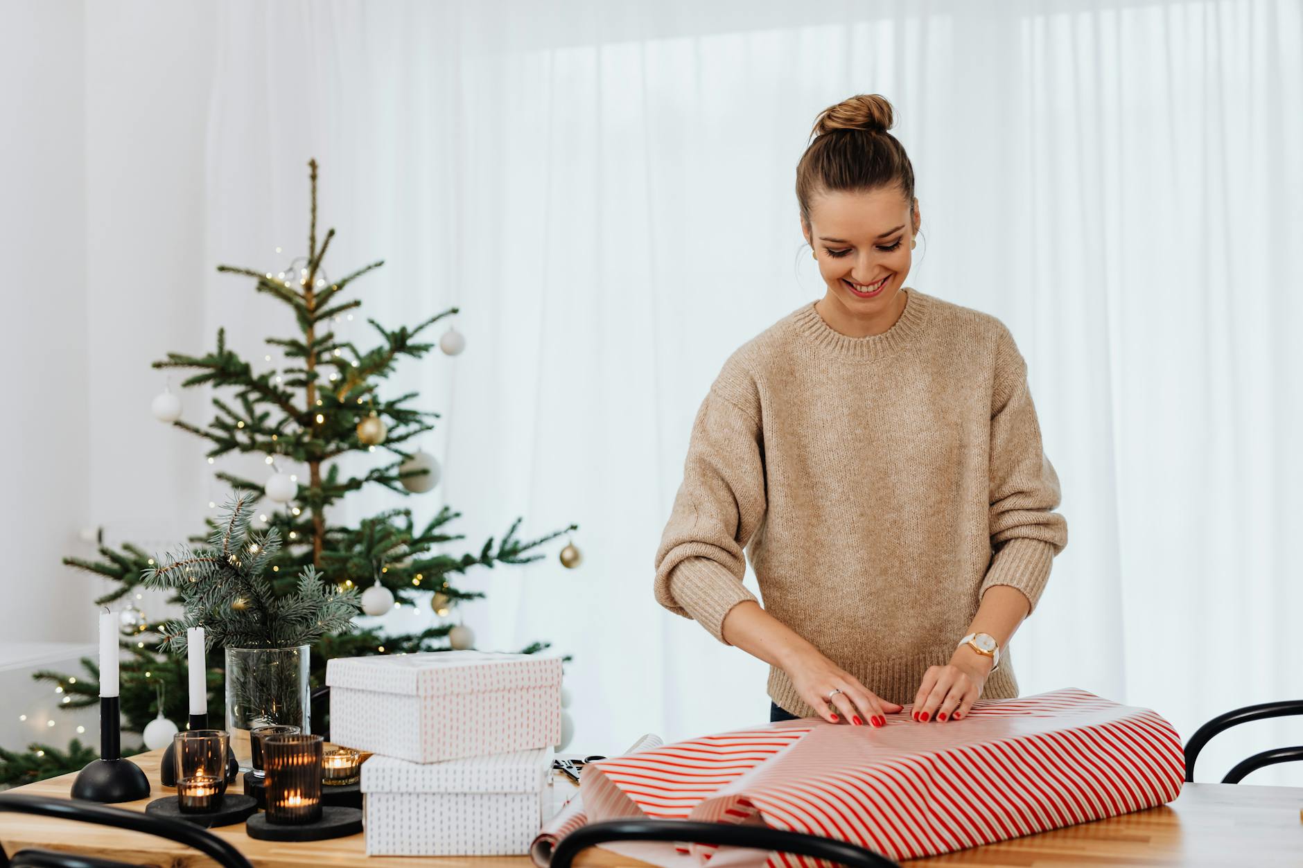 a woman in brown sweater wrapping a gift